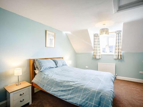 a bedroom with a bed with a blue comforter at 2 Bed in Berwick-upon-tweed oc-81273 in Berwick-Upon-Tweed