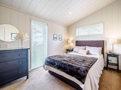 a bedroom with a bed and a dresser and a window at 2 Bed in Wigton oc-80563 in Caldbeck