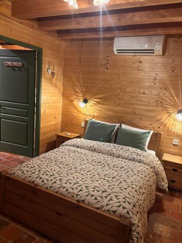 a bedroom with a bed in a room with wooden walls at Le ptit Sabot in Corcieux