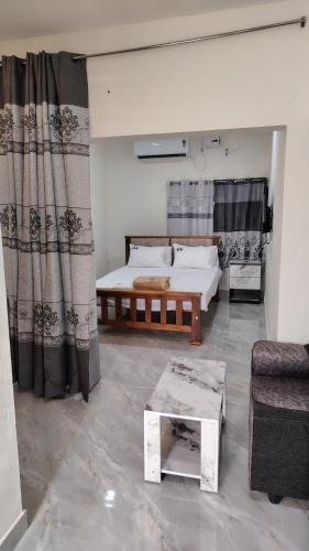a bedroom with a bed and a couch and a table at Golden Stay Inn in Kovakulam