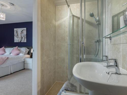 a bathroom with a shower and a sink and a bed at 5 Bed in Melrose oc-79418 in Melrose