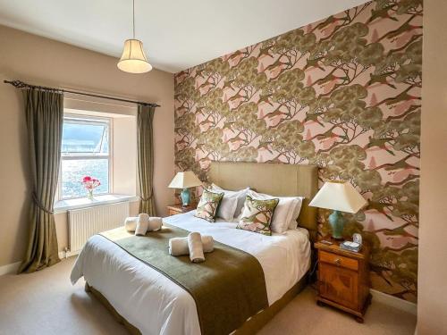 a bedroom with a bed with a floral wall at 6 Bed in Ullapool oc-ca259 in Ullapool