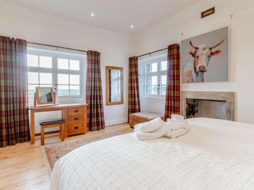 a bedroom with a bed with a cow on the wall at 5 Bed in Anstruther oc-83504 in Pittenweem