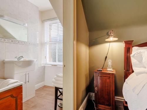 a bedroom with a bed and a bathroom with a sink at 5 Bed in Dunkeld oc-90844 in Birnam