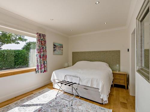 a white bedroom with a bed and a window at 3 Bed in Anstruther oc-96111 in Pittenweem
