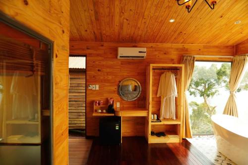 a bathroom with a tub and a sink and a mirror at The Lake Hill Farm Tà Đùng in Biđong