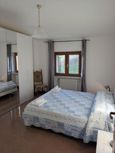 a bedroom with a bed and a chair and a window at Terrazza sul cielo in Bella