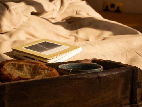 a suitcase with a book and bread and a book at Yarn - Arlo Deluxe Suite in Ballycastle
