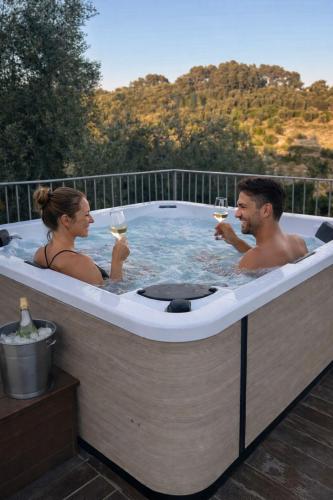 a man and woman drinking wine in a hot tub at Zia Nì Boutique Suites in Peschici