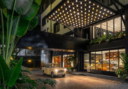 an old car parked in front of a building at Wellesley Hotel in Pune