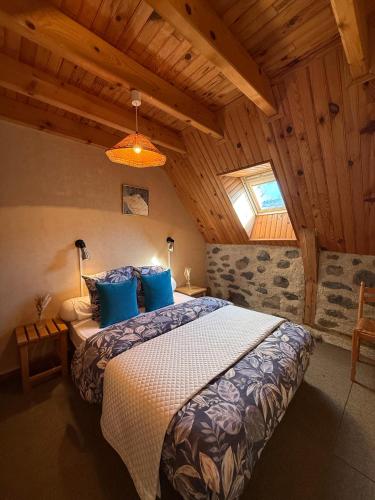 a bedroom with a large bed with blue pillows at Le Domaine Belinay in Paulhac