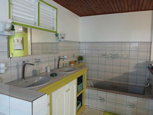 a bathroom with two sinks and a tub at La Villa Rosier in Le François