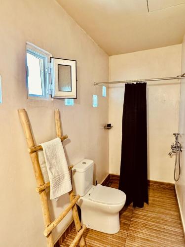 a bathroom with a toilet and a black shower curtain at Harmony Family house in Kerames