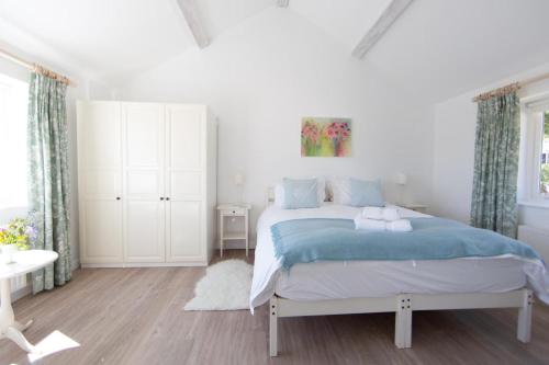 a white bedroom with a bed with blue sheets at 2 Bed in Upper Vobster oc-c39495 in Mells