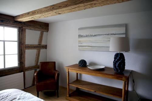 a bedroom with a table with a lamp and a chair at Ferienwohnung Obstgarten in Märstetten
