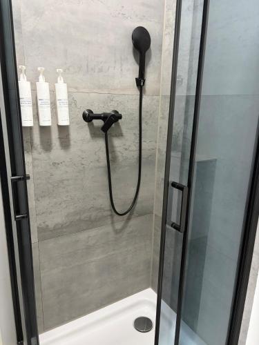a shower with a black shower head in a bathroom at Bright Romantic Studio near sea in Kaštela