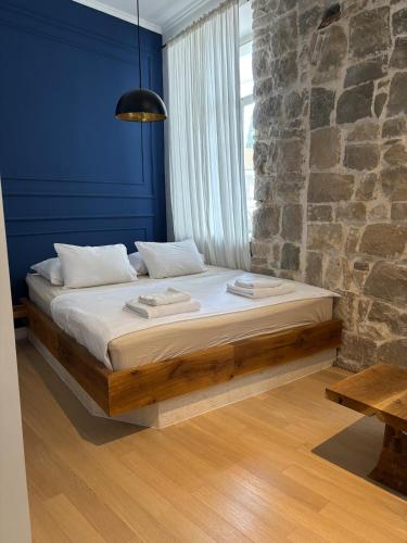 a bed in a room with a stone wall at Bright Romantic Studio near sea in Kaštela