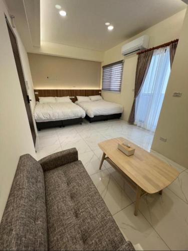 a living room with two beds and a couch at Hualien Leo and Alley Elevator B&B in Hualien City