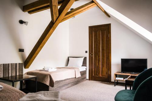 a bedroom with a bed and a tv in a room at Viešbutis DYVAI in Kupiškis