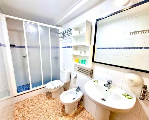 a bathroom with a toilet and a sink and a mirror at Hotel Alaska in San Pedro del Pinatar