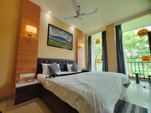 a bedroom with a large bed and a window at Tusker Tea County in Mal bazar