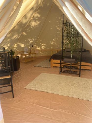 a tent with a table and a rug in a room at Glamping-Dimbo in Krynica Zdrój