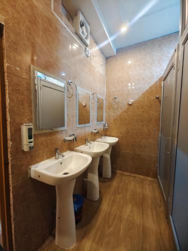 a bathroom with two sinks and two mirrors at Tusker Tea County in Mal bazar