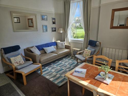 a living room with a couch and chairs and a table at Abbey View Holiday Flats in Torquay
