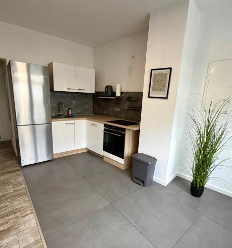 a kitchen with white cabinets and a stainless steel refrigerator at Modernes Apartment im Grünen in Kroppach