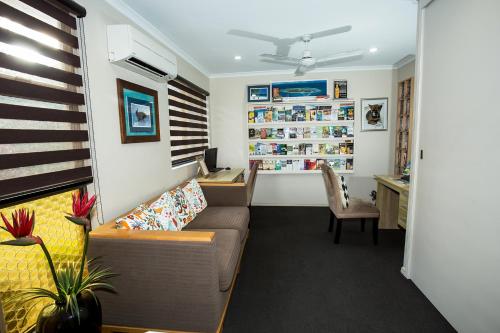 a living room with a couch and a table at Pialba Motor Inn in Hervey Bay