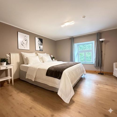 a bedroom with a large bed and a window at Le Petit Château de Harzé - Spa de nage chauffé toute l'année in Aywaille