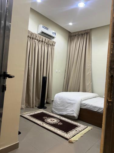 a bedroom with a bed with curtains and a rug at The Mishkan Apartments in Kaduna