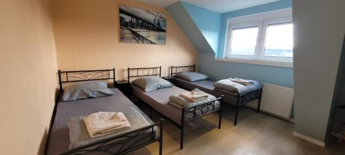 a room with three beds and a window at Privilege - Viel inklusiv! in Viersen