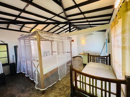 a bedroom with a bed with a mosquito net at Hotel Lean at 83 in Ahangama