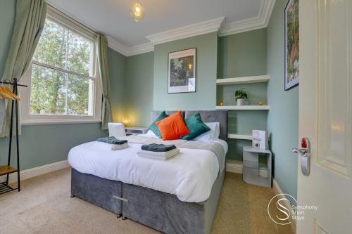 a bedroom with a large bed with colorful pillows at Warwick Place Apartments in Leamington Spa