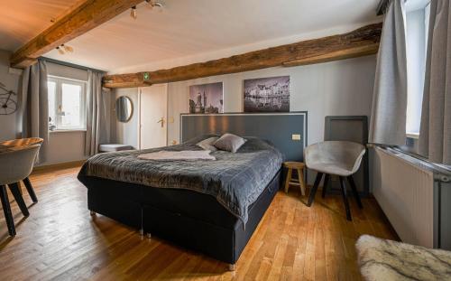 a bedroom with a bed and a table and chairs at Maison Gaston in Bruges