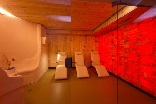 a room with white chairs and a red brick wall at Waren Müritz Hotel Harmonie in Waren