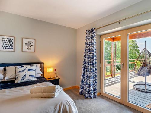 a bedroom with a bed and a sliding glass door at 4 Bed in Kippford oc-95234 in Kippford