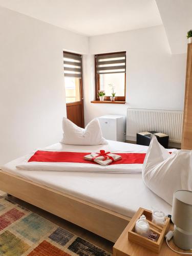 a bedroom with a large bed with a red blanket at NATURA Garden in Cluj-Napoca