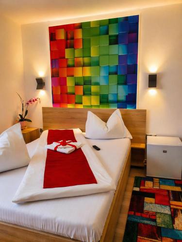 a bedroom with a bed with a colorful painting on the wall at NATURA Garden in Cluj-Napoca