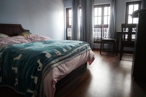 a bedroom with a bed with a green and white blanket at Serenity stay in Kathmandu