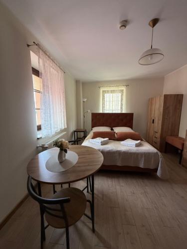 a bedroom with a bed and a table in it at Willa nad rzeką in Kłodzko