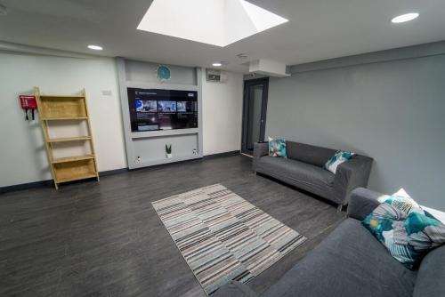 a living room with a couch and a tv at 100 Dale road Studios in Guest house in Birmingham