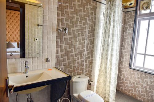 a bathroom with a sink and a toilet and a window at Anutri Hotels & Resorts in Jāmb