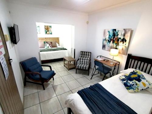 a bedroom with two beds and a table and chairs at Sleep@161 Benade Drive in Bloemfontein