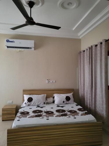 a bedroom with a bed with a ceiling fan at Steco rental in Amasaman