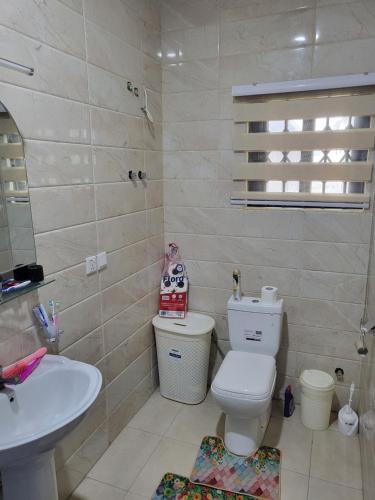 a bathroom with a toilet and a sink at Steco rental in Amasaman