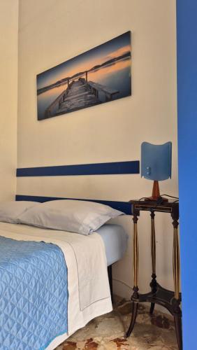a bedroom with a bed and a blue lamp at AA Central Station Historical center in Palermo