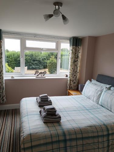 a bedroom with a bed with towels on it at Greenbanks 2 Damerham Self Catering in Damerham