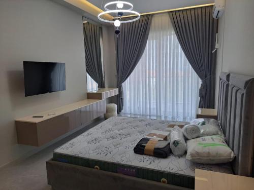 a bedroom with a bed with a tv and a window at Sea Breeze Nardaran open kitchen apartment in Nardaran
